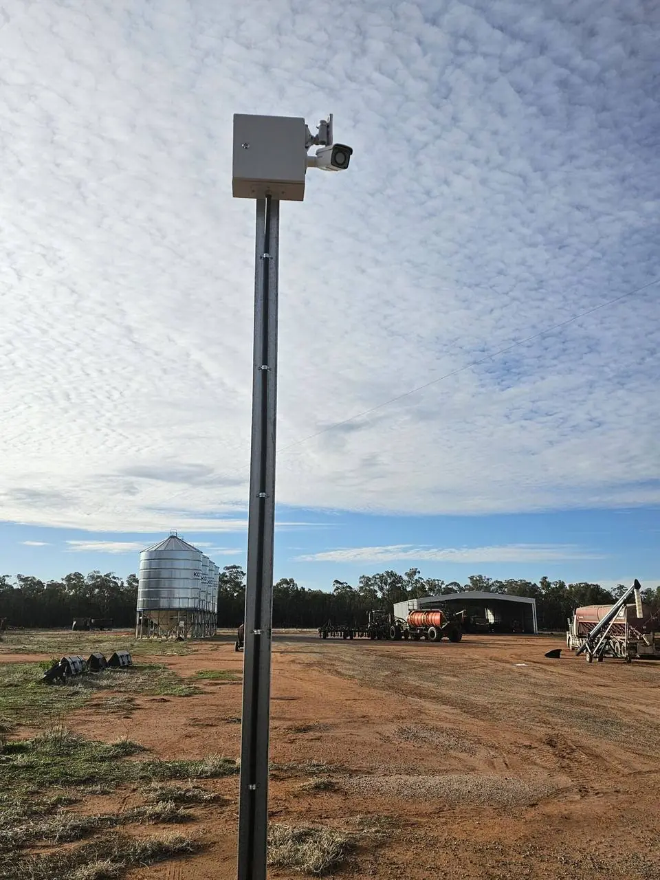 Farm CCTV pole beside sheds and silos
